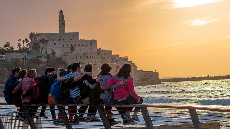 En gruppe unge mennesker nyder solnedgangen ved Tel Aviv